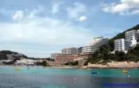 Cala Llonga beach with hotels & apartments behind & to the right 